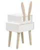 A white bedside table with wooden legs and two wooden bunny ears on top, set against a white background. Náhľad obrázku produktu