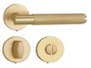 A set of golden matte door hardware, including a lever handle, a WC lock mechanism, and a key escutcheon, displayed against a white background. Produktbild-Vorschau