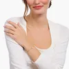 A woman wearing a white long-sleeved shirt and jewelry. Anteprima dell’immagine prodotto