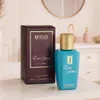 A perfume bottle and its box are displayed on a countertop in a bathroom setting. Produktbild-Vorschau
