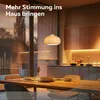 A dining room with a table set for a meal, and a kitchen area in the background with ambient lighting. Produktbild-Vorschau