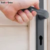 A hand is shown gripping a dark gray door handle on a light wood door. Náhled obrázku produktu
