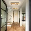 A modern hallway with wooden floors and a staircase, featuring two geometric LED ceiling lights. Produktbild-Vorschau