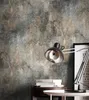 A desk with a lamp, books, and a framed picture against a textured wall. Produktbild-Vorschau