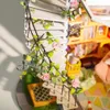 A miniature house staircase with a vine and roses, and a bookshelf in the background. Anteprima dell’immagine prodotto