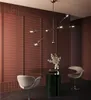 A dining area with a modern chandelier, a round table with chairs, and a decorative wall. Podgląd zdjęcia produktu