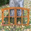 A rusty metal window frame leaning against a tree trunk in an outdoor setting with fallen leaves on the ground. Produktbild-Vorschau
