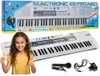 A young girl is shown smiling and giving a thumbs up next to an electronic keyboard and its accessories. Produktbild-Vorschau