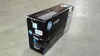 A black box for an HP LaserJet toner cartridge sits on a concrete floor. Voir les images du produit