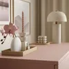 A console table with decorative items like a vase, flowers, candles, and a lamp. Produktbild-Vorschau