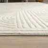A close-up view of a textured, cream-colored rug with a geometric pattern, lying on a light wooden floor. Produktbild-Vorschau