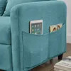 A close-up view of the side of a teal sofa, showing two pockets with a tablet and a magazine inserted. Anteprima dell’immagine prodotto
