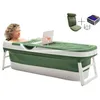 A woman is relaxing in a green and white foldable bathtub with a laptop and a glass of wine. Produktbild-Vorschau