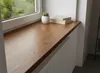 A wooden windowsill with a potted plant and books. Produktbild-Vorschau