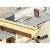 A digital angle gauge is placed on the table of a circular saw next to a piece of wood. Produktbild-Vorschau