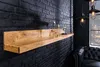 A wooden shelf mounted on a black brick wall, decorated with two champagne glasses and a small decorative item. Produktbild-Vorschau