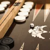 A close-up view of a backgammon board with dice and game pieces. Voir les images du produit