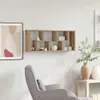 A wooden wall shelf with decorative items displayed on it, next to a framed artwork and a chair. Náhled obrázku produktu
