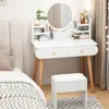 A white vanity table with a round mirror and wooden legs, placed next to a bed. A white stool is in front of the table. Anteprima dell’immagine prodotto