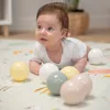 A baby is lying on a play mat with several colorful balls around it. Náhľad obrázku produktu