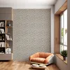 A modern living room with a textured wall, a bookshelf, and a chair. Produktbild-Vorschau