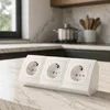 A white triple power strip sits on a marble countertop in a modern kitchen. Produktbild-Vorschau