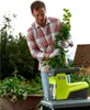 A man is using a green electric shredder in a garden setting. Anteprima dell’immagine prodotto