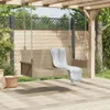 A beige poly rattan hanging bench with a white blanket draped over it, suspended from a wooden pergola in an outdoor setting with a wooden deck and greenery. Náhled obrázku produktu