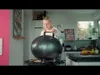 A woman is opening a black electric grill in a kitchen. Produktbild-Vorschau