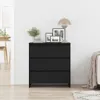 A black wooden sideboard with three drawers is shown in a room with a white wall and light wooden floor. There are framed pictures and a lamp on top of the sideboard. Náhled obrázku produktu