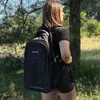A person wearing a backpack in a forest. Produktbild-Vorschau
