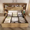 A storage bed with a headboard featuring shelves and compartments, shown with bedding and storage items inside. Náhled obrázku produktu