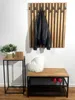 A hallway or entryway setting with a coat rack, a small table with decor, and a bench with shoes. Náhled obrázku produktu