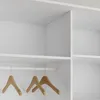 A close-up view of a white wardrobe interior with a hanging rail and wooden hangers. Produktbild-Vorschau