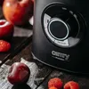 A close-up shot of a black stand mixer with fruit on a wooden surface. Produktbild-Vorschau