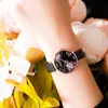 A close-up shot of a woman's wrist wearing a watch, surrounded by flowers. Náhled obrázku produktu