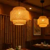 Two bamboo pendant lights hang over a dining table in a restaurant setting. Náhled obrázku produktu