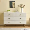 A white dresser with gold accents is shown in a well-lit room with a yellow wall. Anteprima dell’immagine prodotto