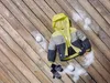 A children's winter jacket, mittens, and snowballs are arranged on a wooden deck with scattered snow. Produktbild-Vorschau