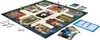 A Cluedo detective board game is laid out on a white background, with game pieces, dice, and cards visible. Podgląd zdjęcia produktu