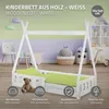 A white wooden children's bed with a teepee-like frame, set up in a child's room with toys and decor in the background. Produktbild-Vorschau