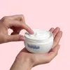 A person's hands are holding a jar of cream. Anteprima dell’immagine prodotto