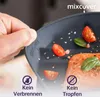 A hand holding a gray silicone baking dish with salmon, tomatoes, and basil inside. Produktbild-Vorschau