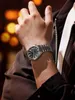 A close-up shot of a man's wrist wearing a silver watch with a black face. Anteprima dell’immagine prodotto