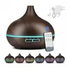 A dark wood-grain aroma diffuser with a remote control and power adapter, shown with multiple color options at the bottom. Produktbild-Vorschau
