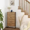 A shoe cabinet is placed next to a staircase in a room with a plant and a chair. Anteprima dell’immagine prodotto