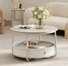 A round coffee table with a fabric basket storage underneath, placed in a living room setting with a sofa and a side table in the background. Produktbild-Vorschau