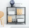 A shelf unit with storage boxes and binders, next to a chair. Produktbild-Vorschau