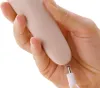 A hand holding a beige electronic foot file and a white charging cable. Voir les images du produit