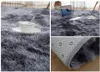 A collage of images showing a shaggy plush rug in dark gray, with a close-up of its texture, a lifestyle shot with a laptop and cup, and a view of the rug's underside. Podgląd zdjęcia produktu